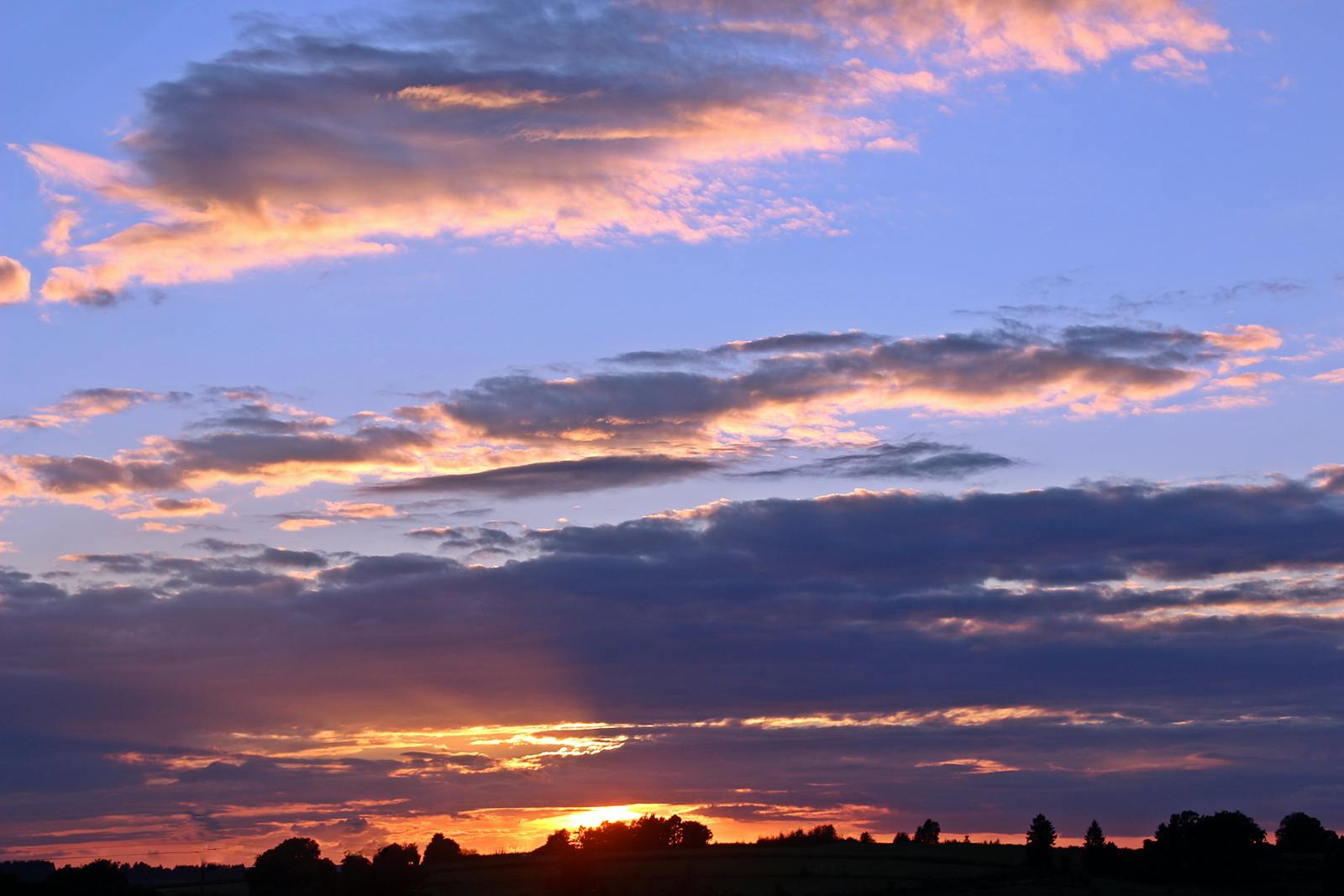 Coucher de soleil avec ciel chaud et silhouettes — illustration de la température de couleur et de la balance des blancs en photographie